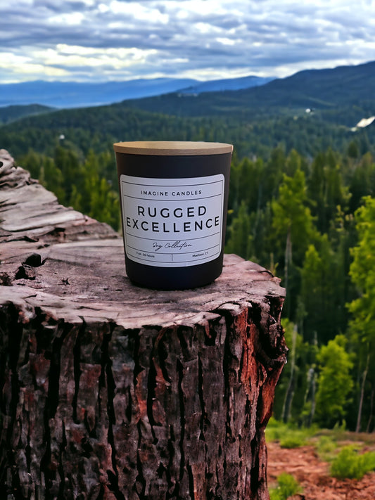 A candle rests on a stump overlooking the woods, embodying the essence of Rugged Excellence. The label reads 'Rugged Excellence', evoking the feeling of a long day and the comfort of a favorite cologne. Fragrance notes include petitgrain, cardamom, lemon, orange, fir, jasmine, rosemary, rose, lily of the valley, vetiver, musk, oak moss, and Brazilian rosewood."